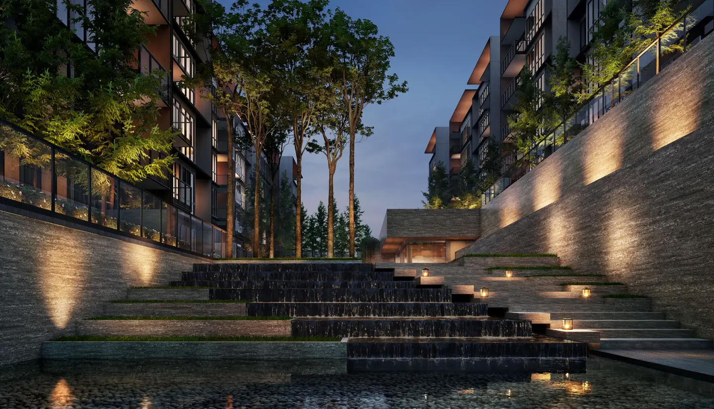 A stepped water feature lit at night between the residential blocks